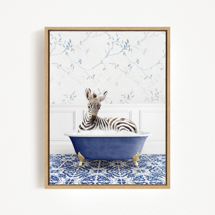 A zebra is sitting in a blue bathtub, surrounded by a patterned tile floor and a floral wallpaper background.