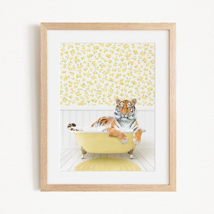 A tiger is sitting in a yellow bathtub, surrounded by a yellow and white floral pattern on the wall behind it.