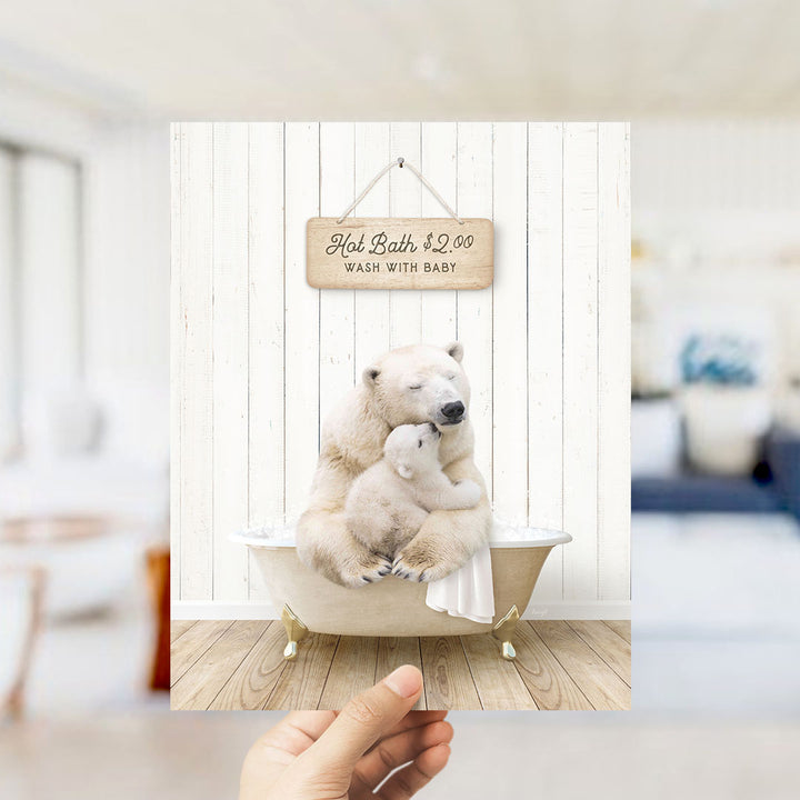 A hand holding a framed image of a polar bear sitting in a bathtub, with a sign above it that says "Hot Bath $2.00 WASH WITH BABY".