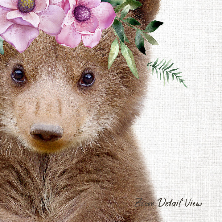 A close-up of a bear's face with pink flowers on its head, set against a white background.