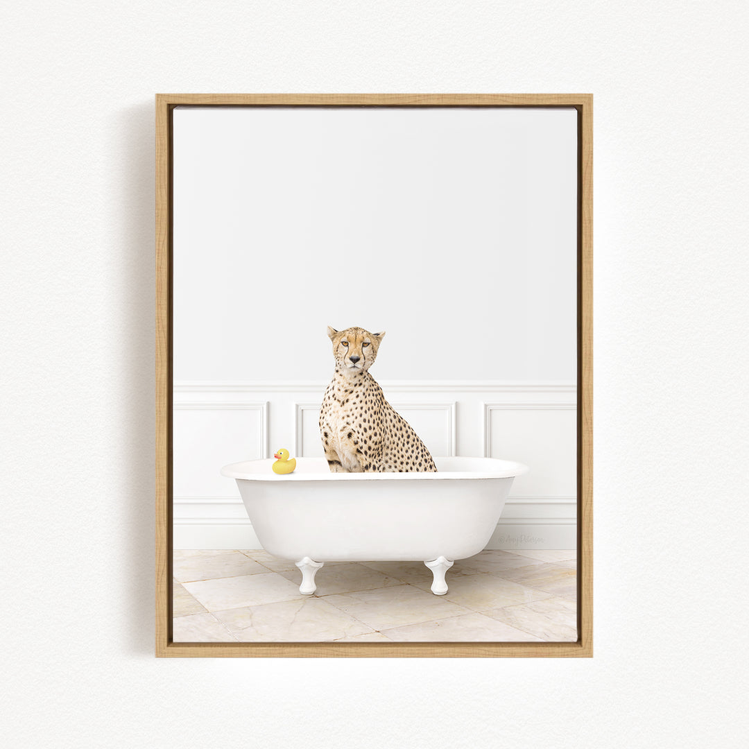 A cheetah sits in a white bathtub, with a yellow rubber duck floating in the water.