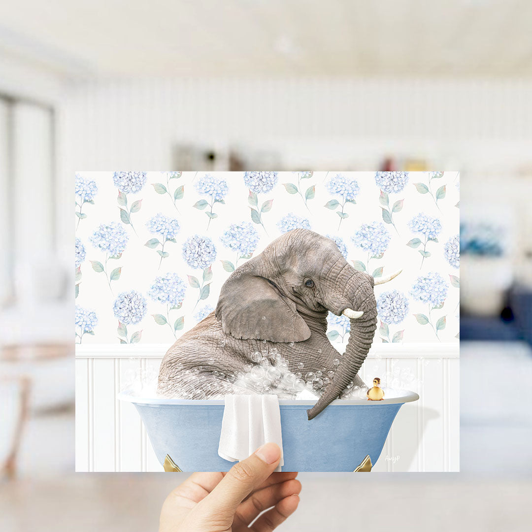 A gray elephant is sitting in a blue bathtub filled with water, surrounded by blue flowers.