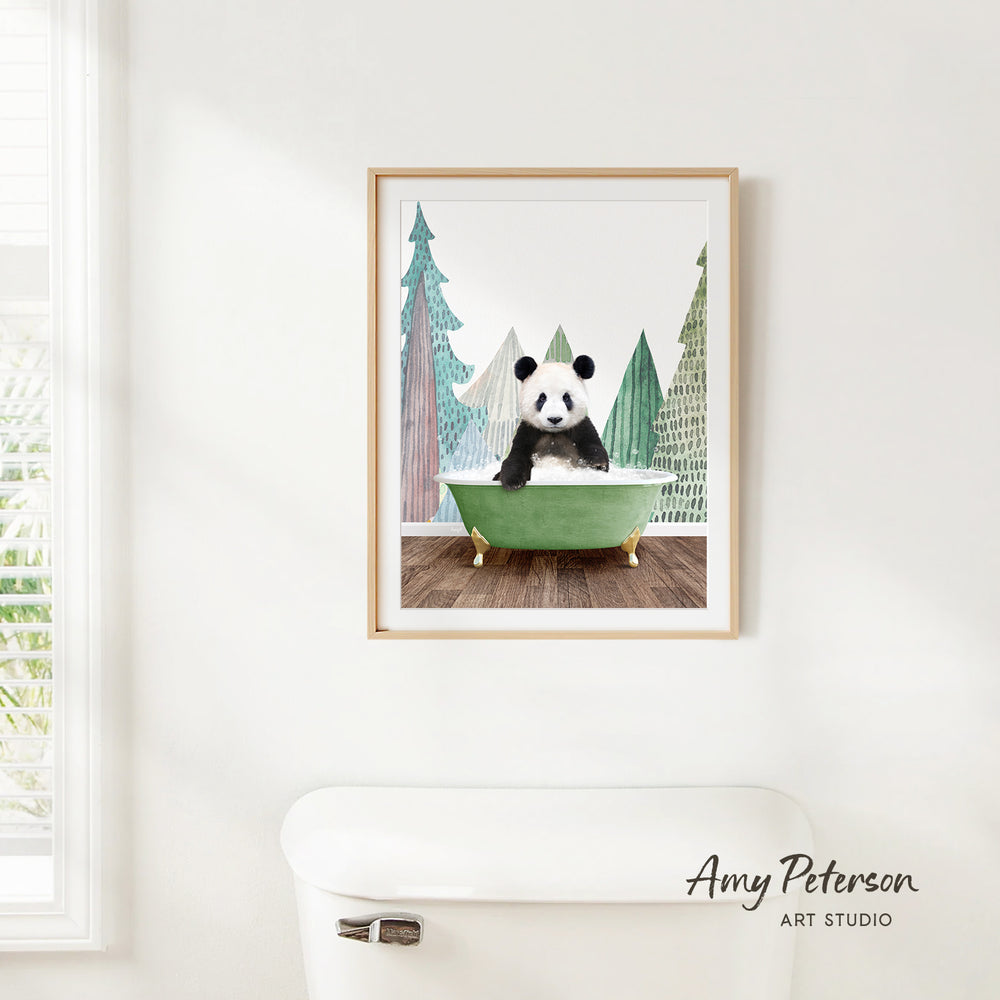 A framed print of a panda bear sitting in a green bathtub, surrounded by trees, is hanging on a white wall.