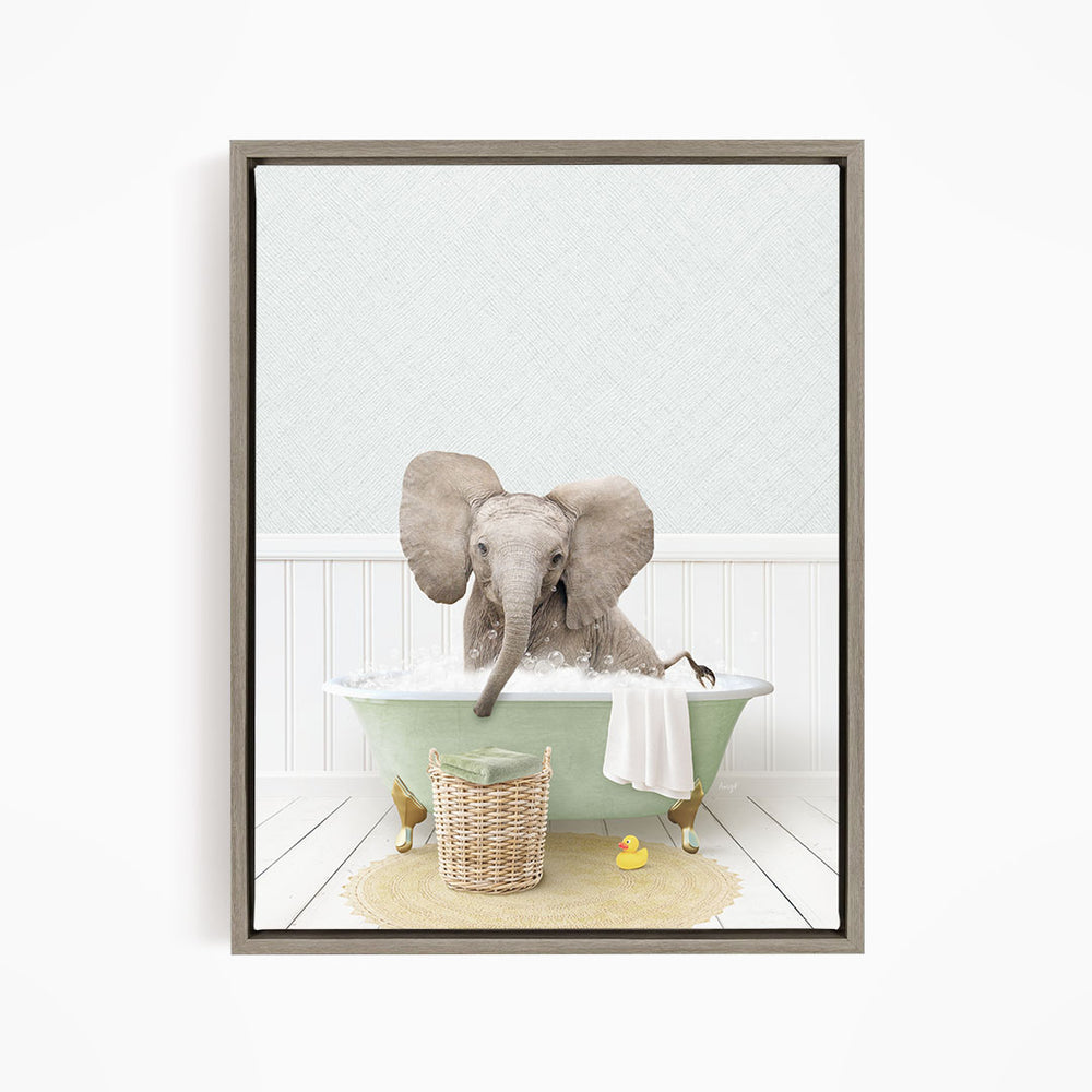 A gray elephant is sitting in a green bathtub filled with water, surrounded by a yellow rubber duck and a basket.