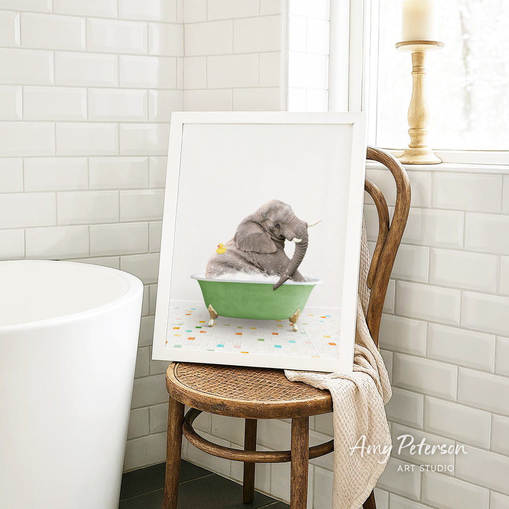 A framed image of a gray cat sitting in a green bathtub, with a yellow rubber duck floating in the water.
