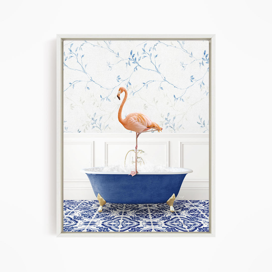 A pink flamingo stands on the edge of a blue bathtub, with a patterned tile floor and a floral wallpaper in the background.