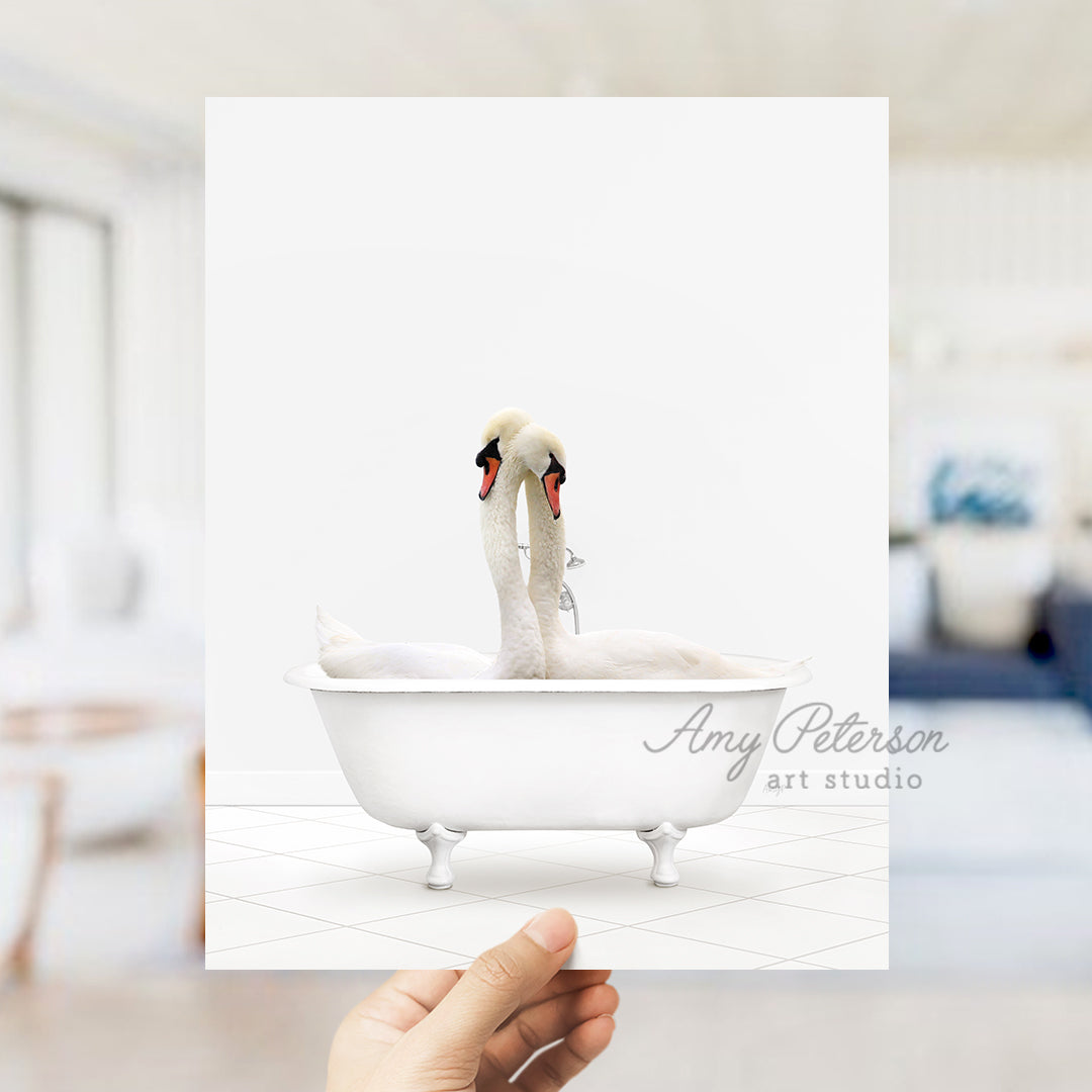 a person holding up a picture of two swans in a bathtub