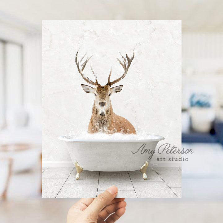 a hand holding up a photo of a deer in a bathtub