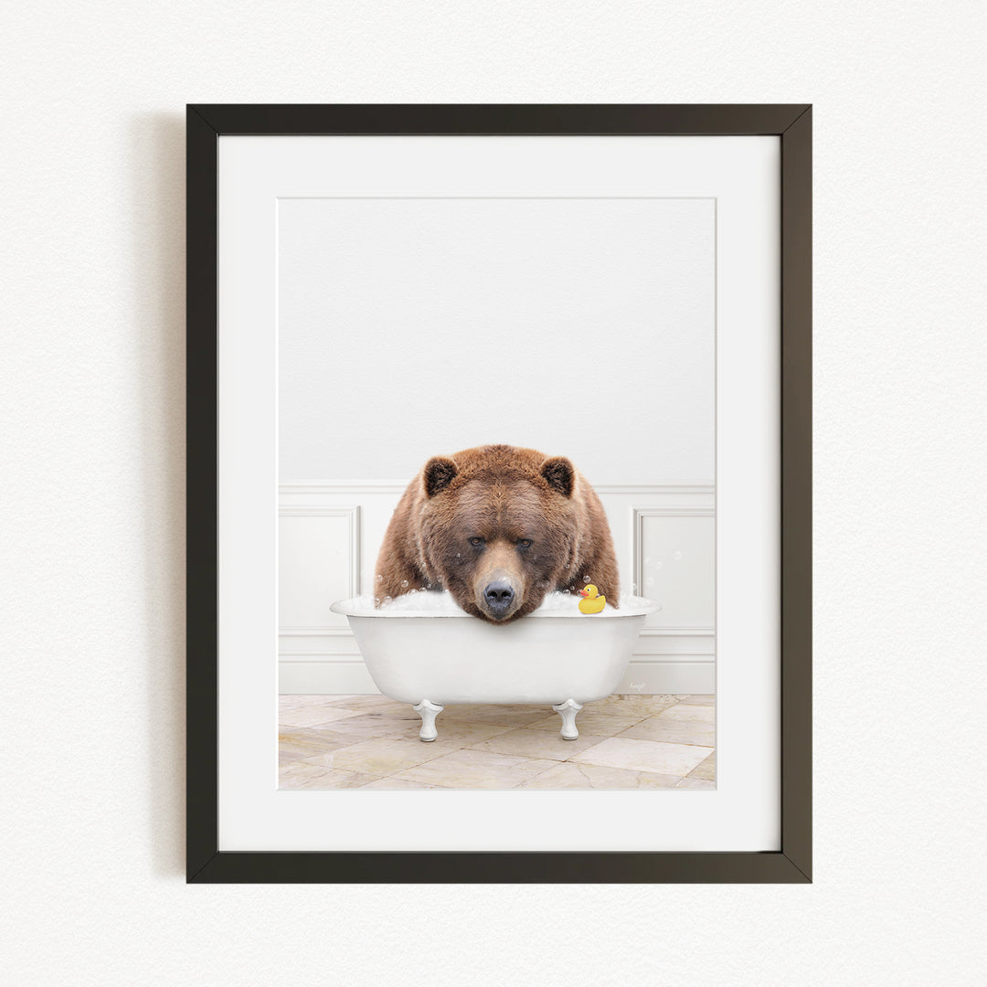 A brown bear is sitting in a white bathtub, surrounded by a yellow rubber duck.