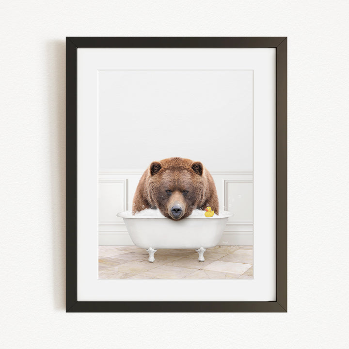 A brown bear is sitting in a white bathtub, surrounded by a yellow rubber duck.