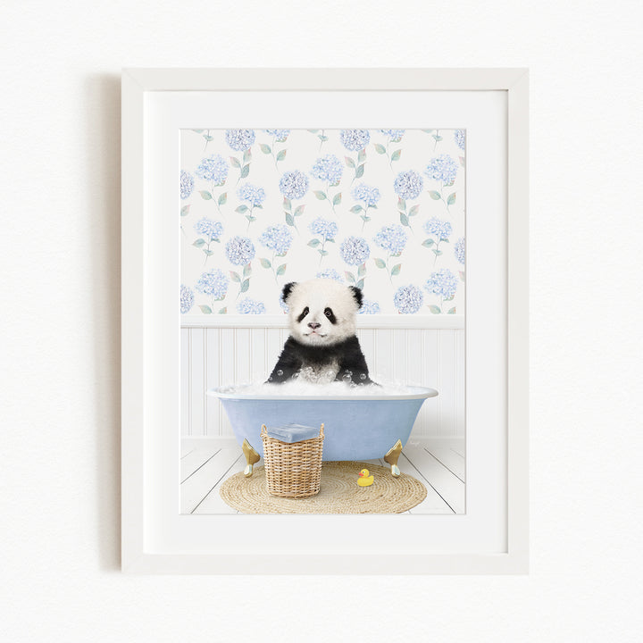 A panda bear sitting in a blue bathtub filled with bubbles, surrounded by a floral patterned wall and a basket of rubber ducks.