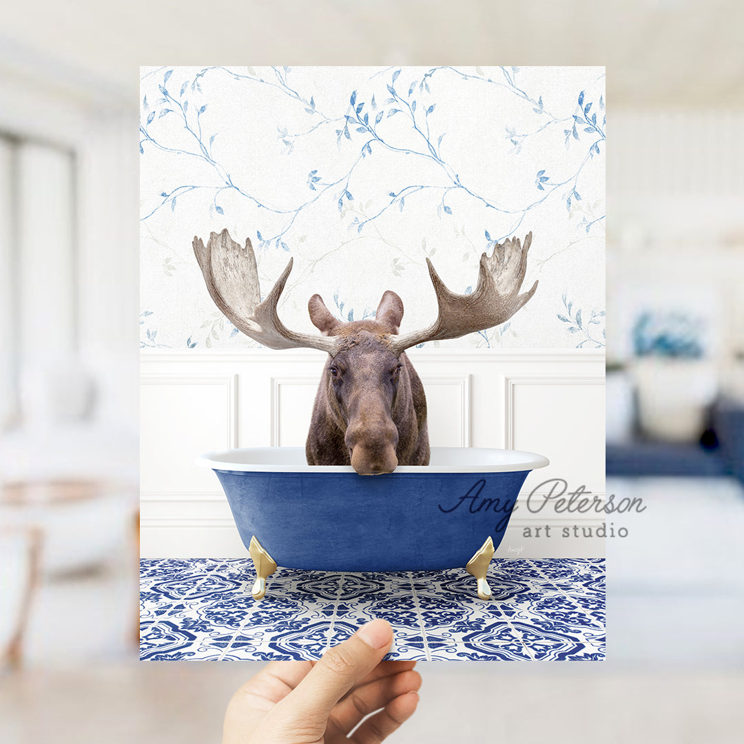 a person holding up a card with a moose head in a bathtub