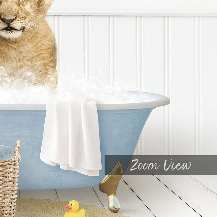 A cat is sitting in a blue bathtub filled with bubbles, surrounded by a yellow rubber duck and a white towel.