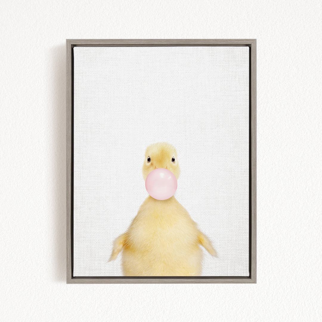 A cute yellow duck blowing a bubble with a pink bubble gum bubble.