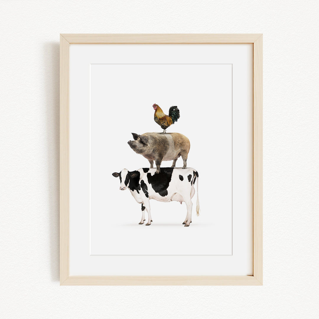 A framed illustration depicting a pig, cow, and rooster standing on top of each other.
