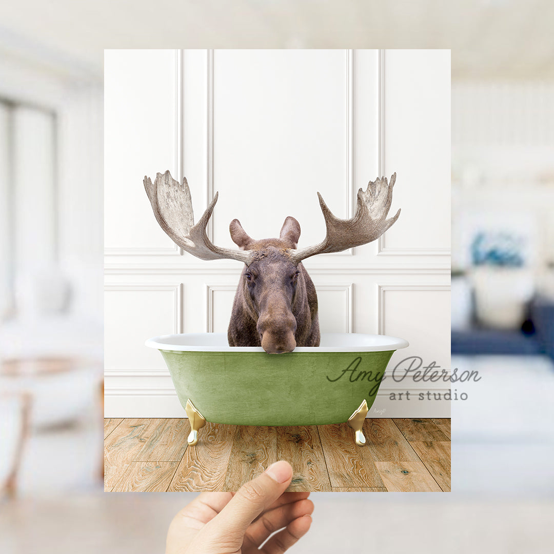 a hand holding a card with a moose in a bathtub