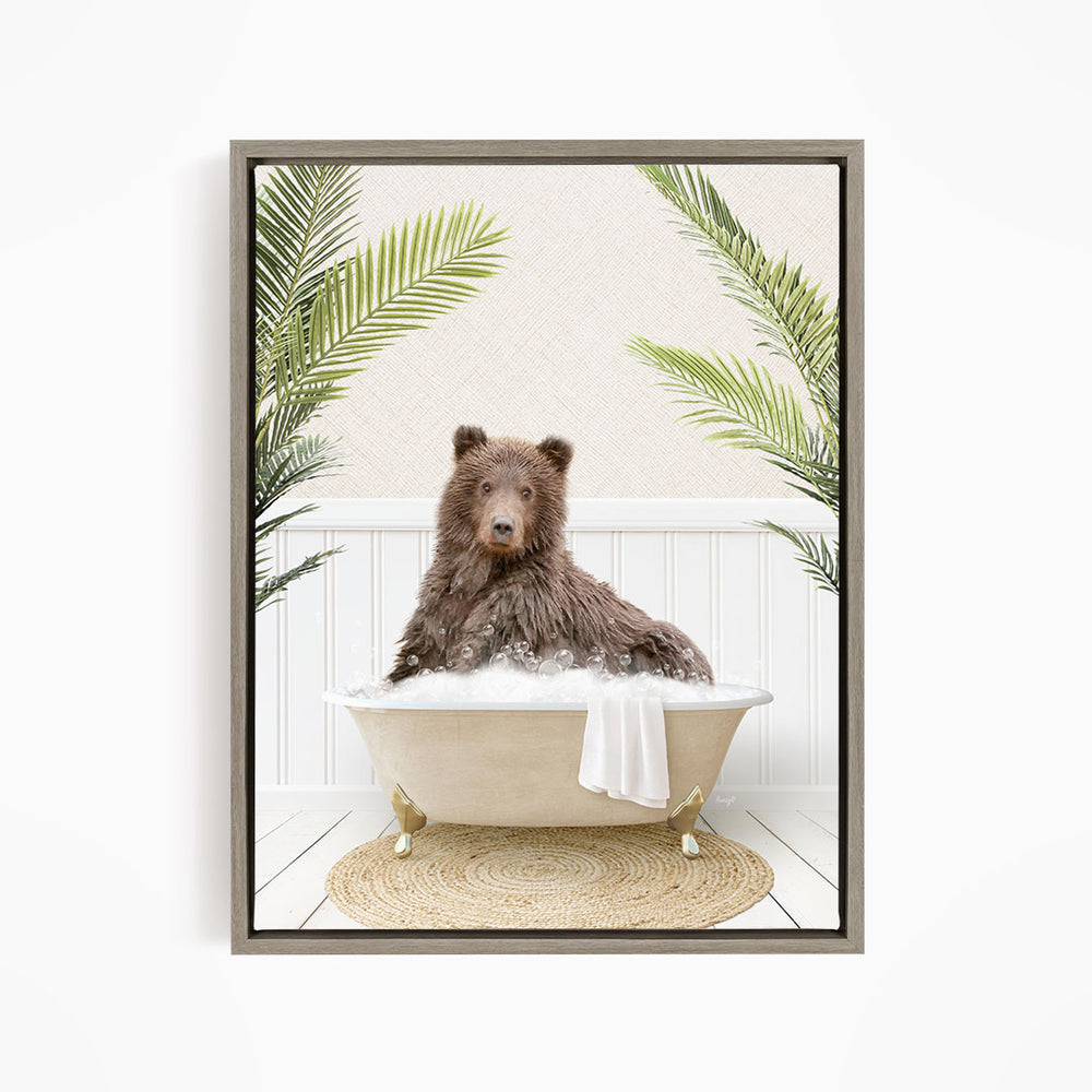 A brown bear sitting in a white bathtub filled with water, surrounded by green palm leaves.