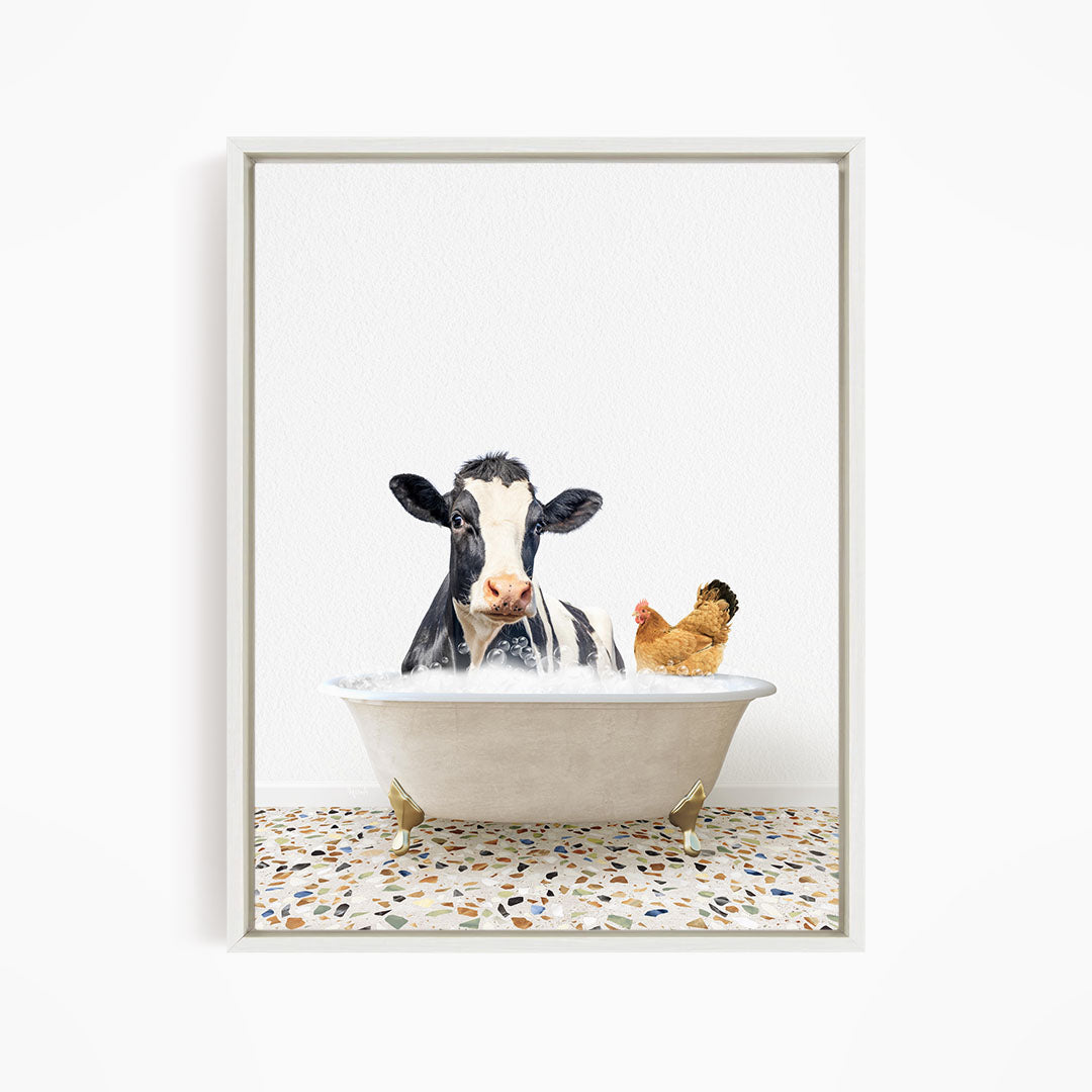 A black and white cow is sitting in a white bathtub, with a chicken standing nearby, both appearing to enjoy the bath together.
