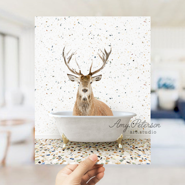 a hand holding up a card with a picture of a deer in a bathtub