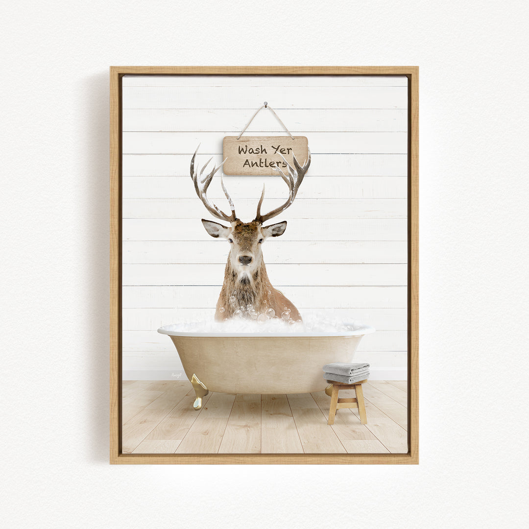 A deer with antlers is sitting in a bathtub filled with water, with a sign above it that says "Wash Your Antlers".