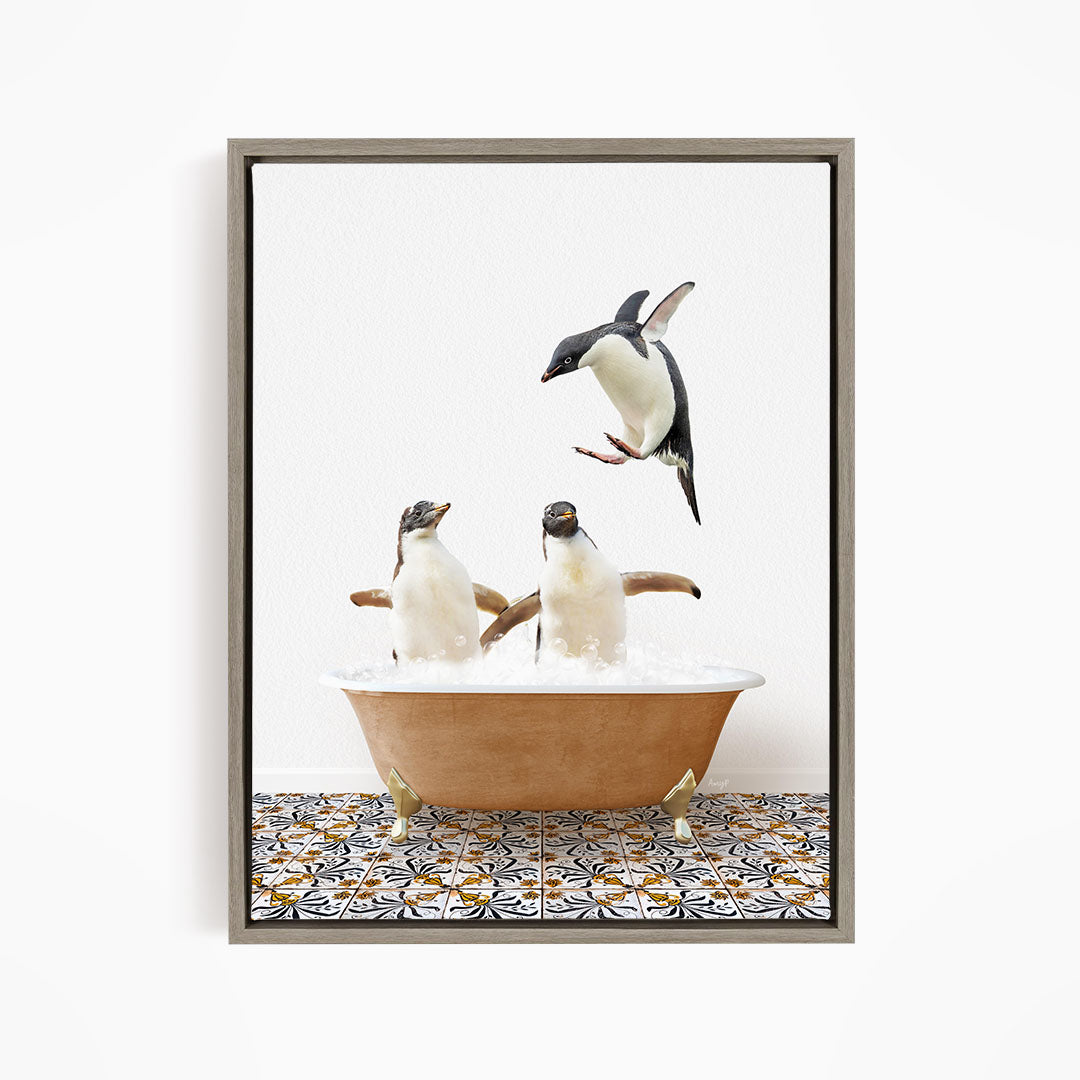 A framed image depicting two penguins standing in a bathtub filled with water, with one penguin flying out of the tub.