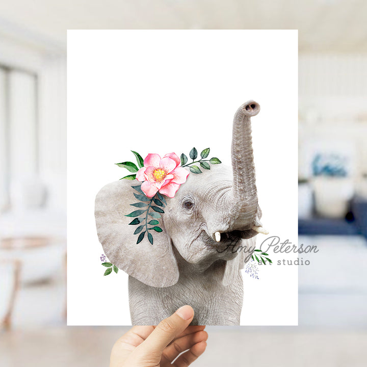 a hand holding up a card with an elephant with a flower on it