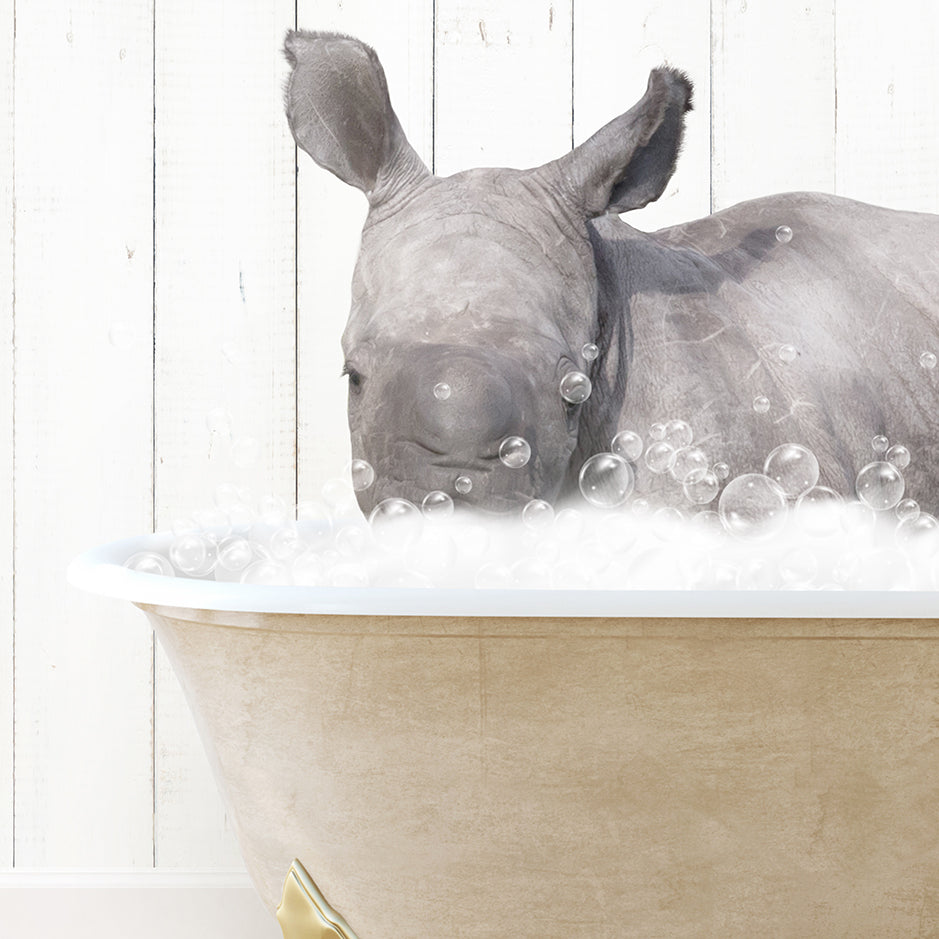 a rhino laying down in a bathtub filled with bubbles