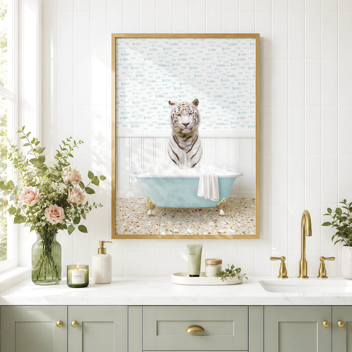 A framed image of a tiger sitting in a bathtub, surrounded by flowers and a green vase, is displayed on a white tiled wall above a bathroom sink.