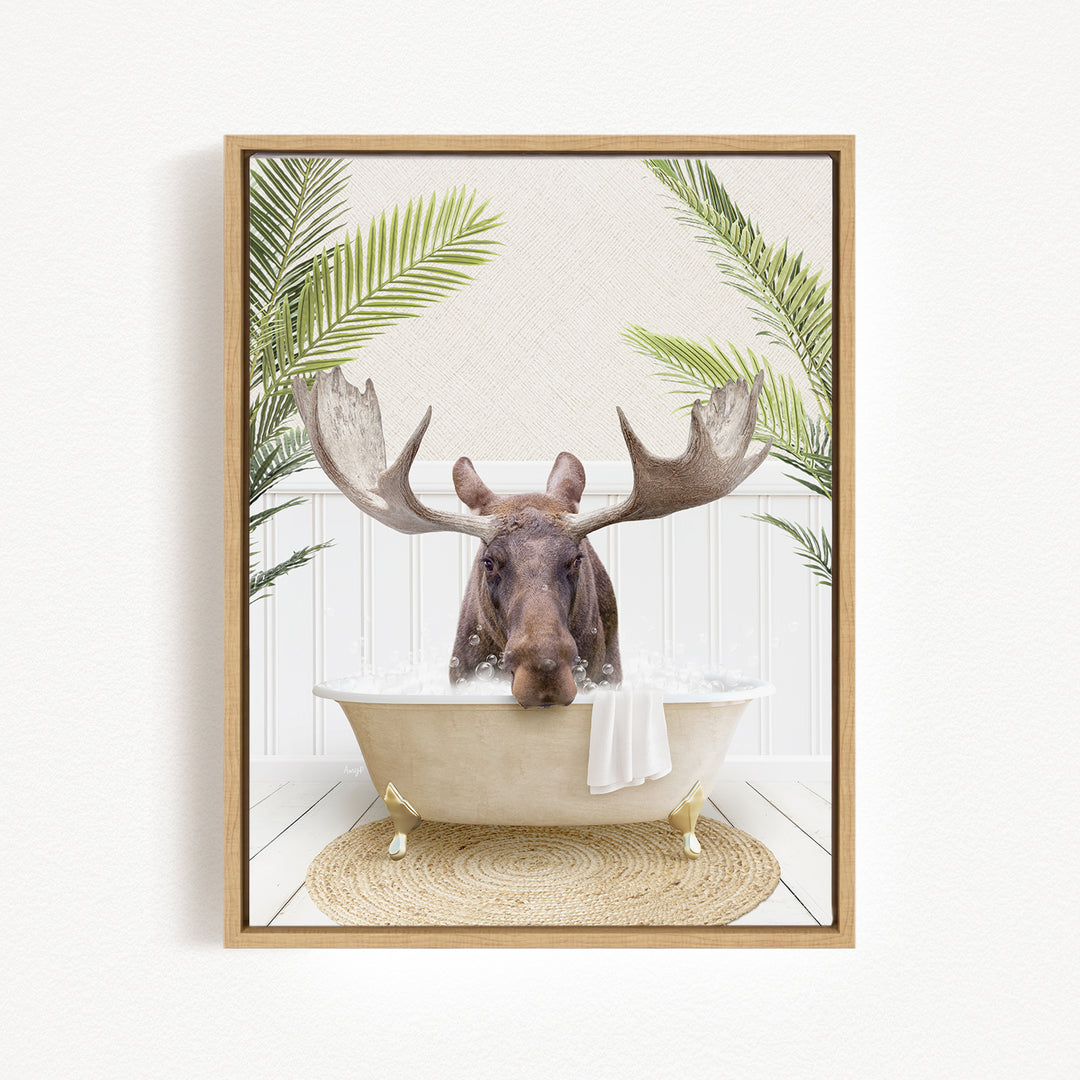 A moose with large antlers is sitting in a bathtub filled with water, surrounded by green palm leaves.
