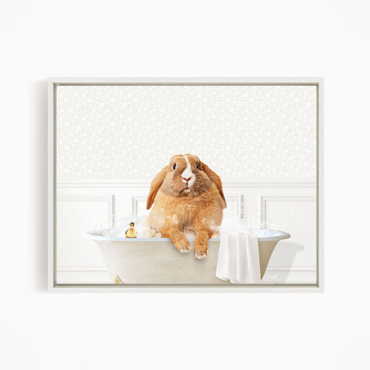 A brown rabbit sitting in a bathtub filled with water, with a towel and a small toy nearby.
