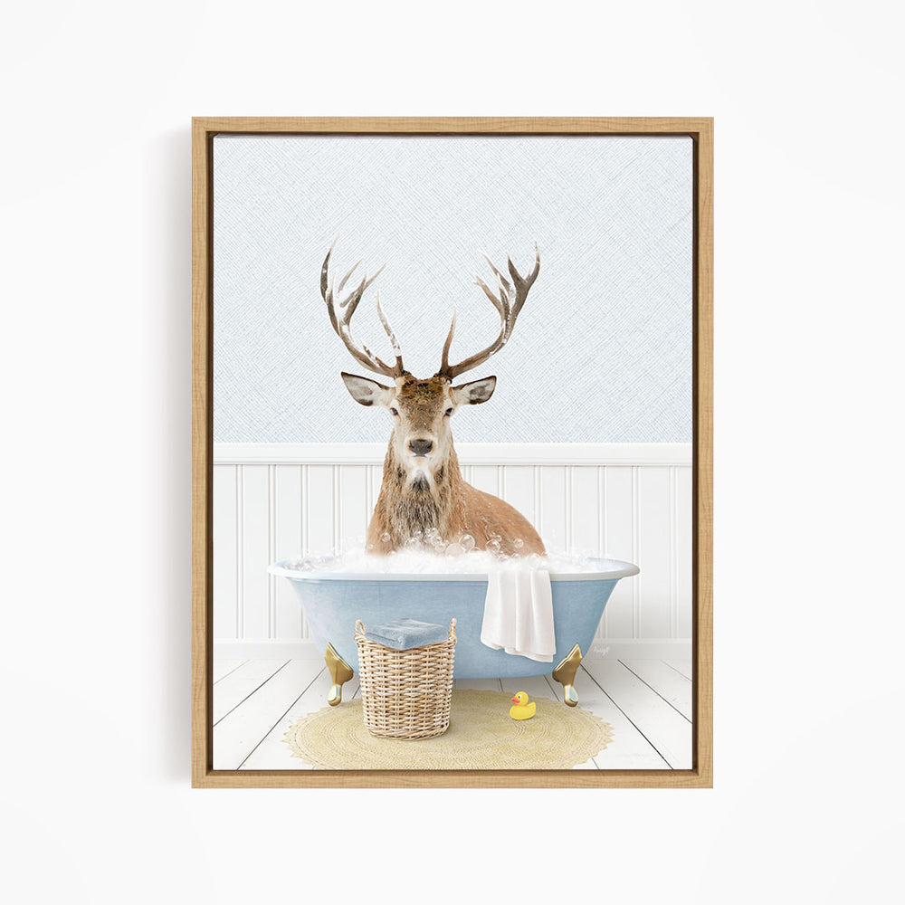 A deer with large antlers is sitting in a blue bathtub filled with water, surrounded by rubber ducks.