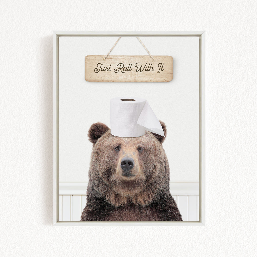 A brown bear wearing a toilet paper roll on its head, with a wooden sign above that says "Just Roll With It".