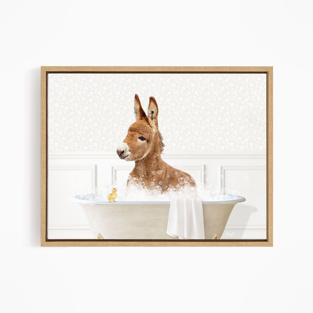 A donkey is sitting in a bathtub filled with water, surrounded by a towel and a small yellow duck.