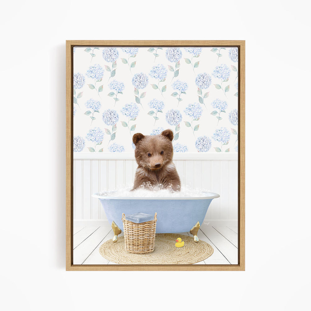 A brown bear sitting in a blue bathtub filled with water, surrounded by a wicker basket and rubber duckies.