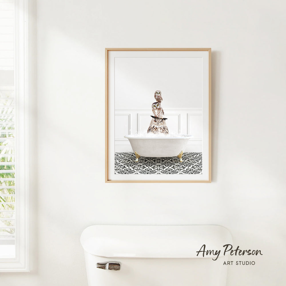 A framed image of a person sitting in a bathtub is hanging on a white wall in a bathroom.