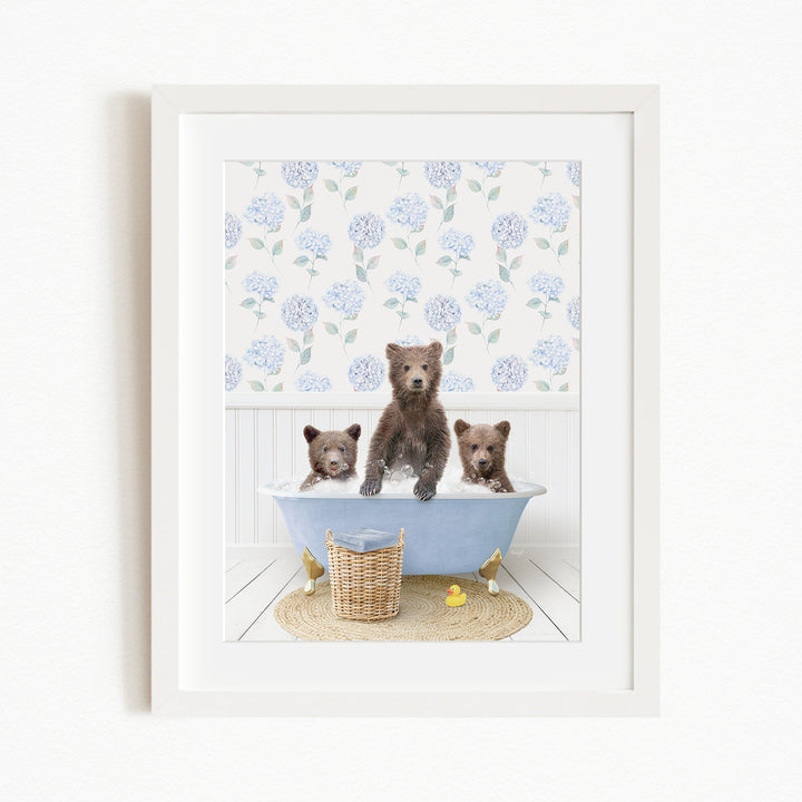 A framed image depicting three brown bears sitting in a blue bathtub, surrounded by a floral patterned wall and a yellow rubber duck.
