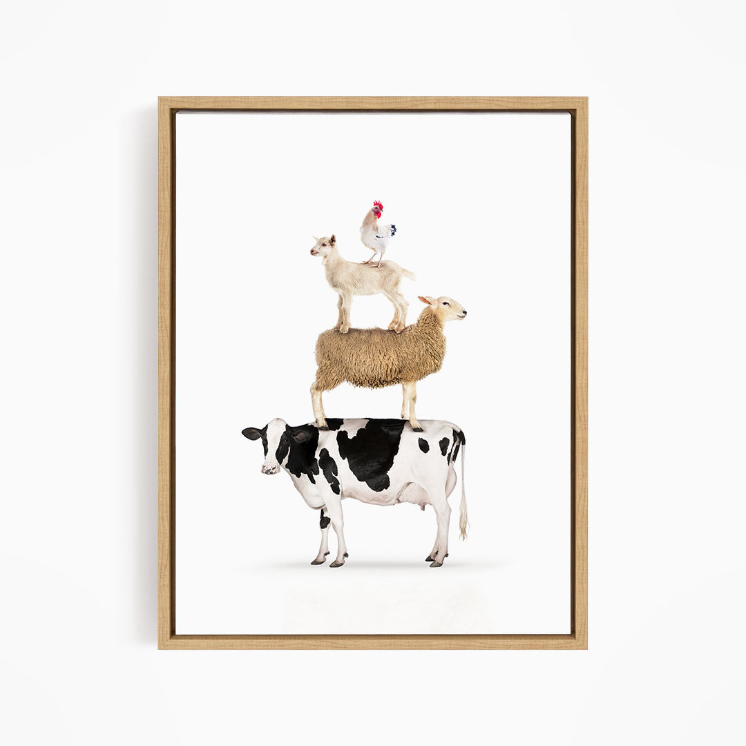 A framed image depicting a cow, sheep, and chicken stacked on top of each other.