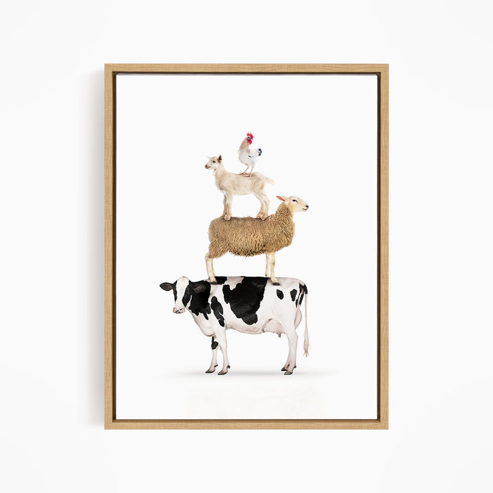 A framed image depicting a cow, sheep, and chicken stacked on top of each other.