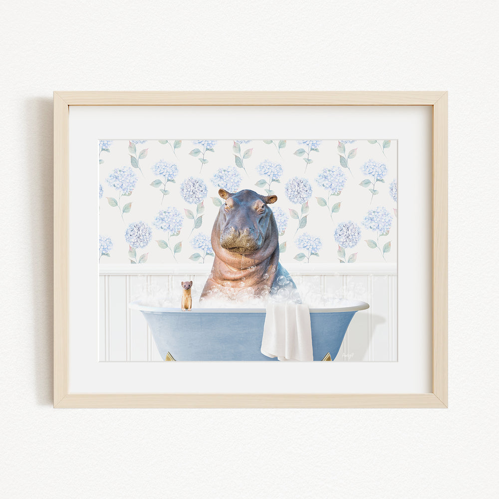 A framed image depicting a hippopotamus sitting in a bathtub filled with water, surrounded by blue hydrangea flowers.