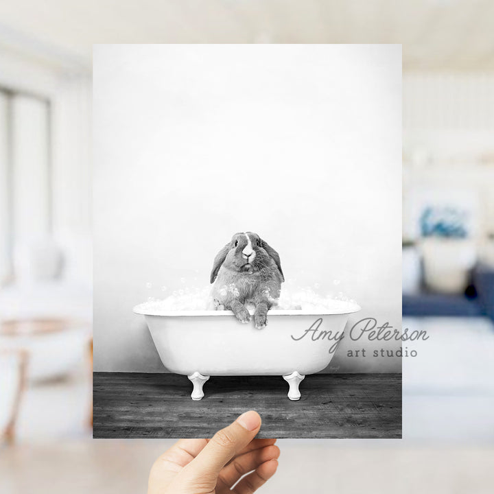 a person holding up a card with a picture of a rabbit in a bathtub