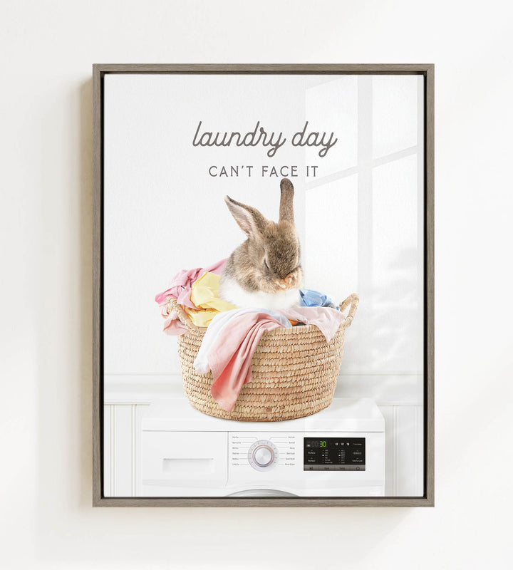 A rabbit sitting in a woven laundry basket filled with clothes, with the text "laundry day can't face it" above the image.