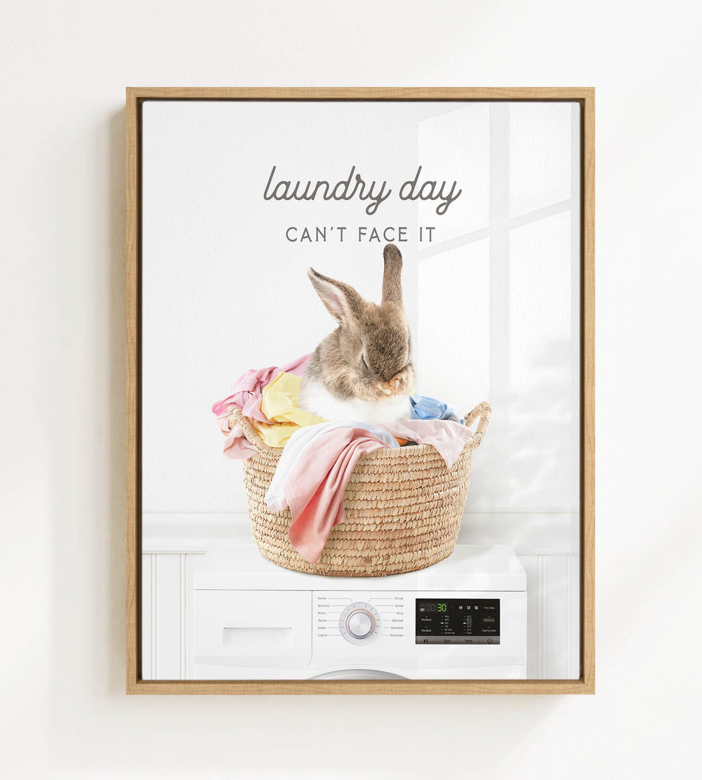 A rabbit sitting in a basket filled with laundry, with the text "laundry day can't face it" above the image.