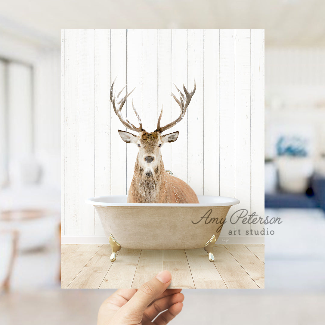 a hand holding a photo of a deer in a bathtub