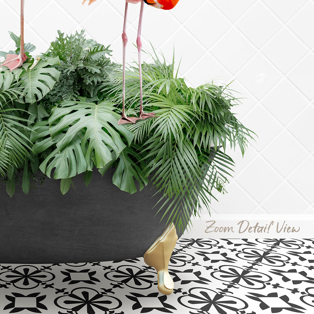 A potted plant with large green leaves sits on a patterned tile floor, with a pair of legs visible underneath the plant.