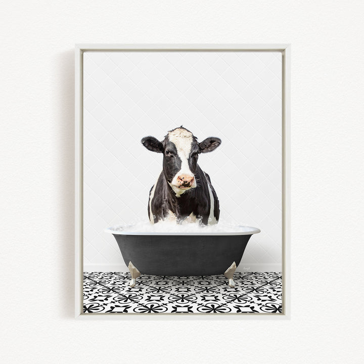 A black and white cow is sitting in a black bathtub filled with water, creating a whimsical and humorous scene.