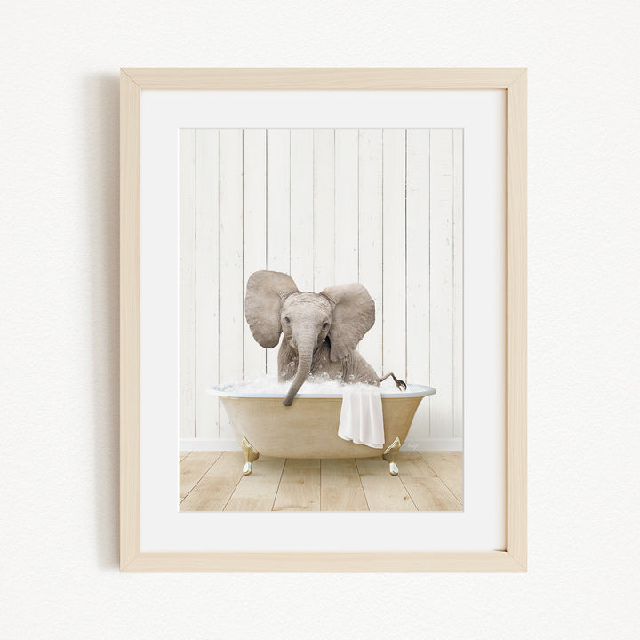 A baby elephant sitting in a bathtub filled with water, with its trunk submerged in the water.