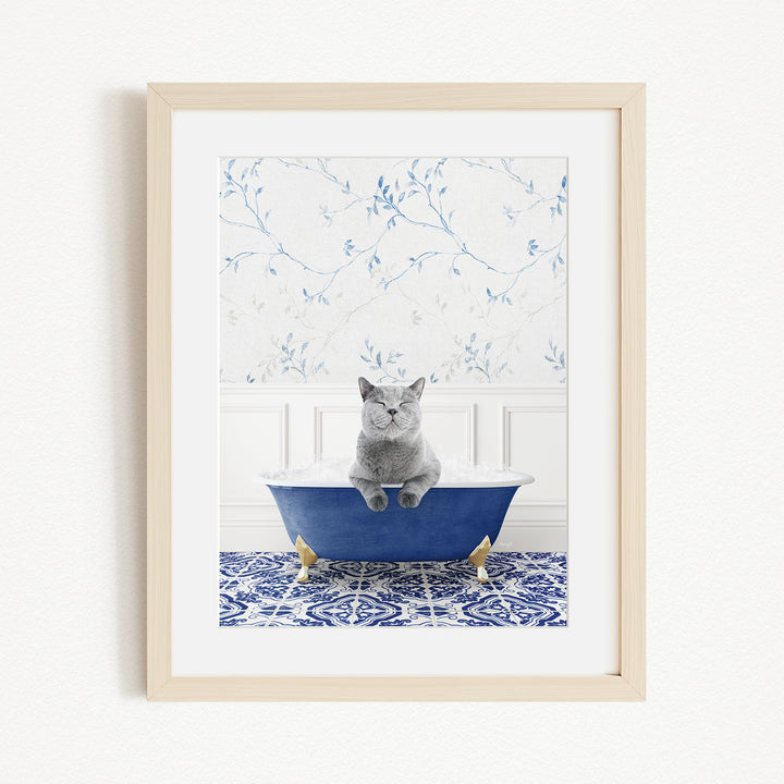 A gray cat sitting in a blue bathtub, with a patterned tile floor and a floral wallpaper in the background.