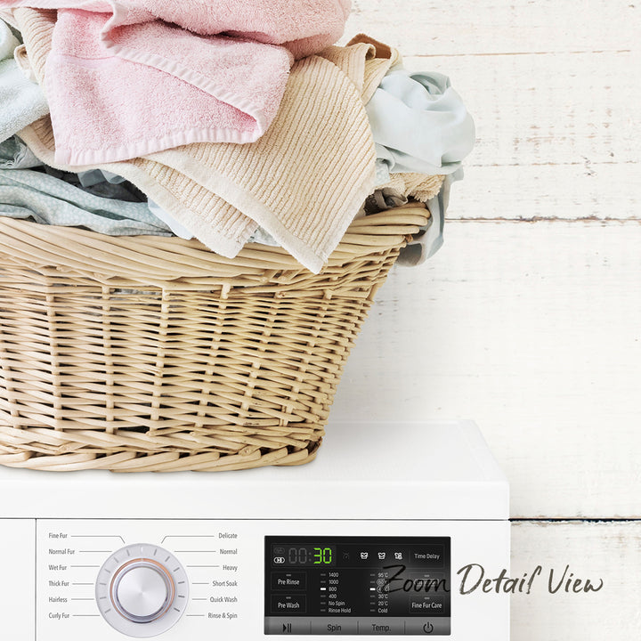 A wicker laundry basket filled with clothes sits on top of a white washing machine, with a digital display and control panel visible.
