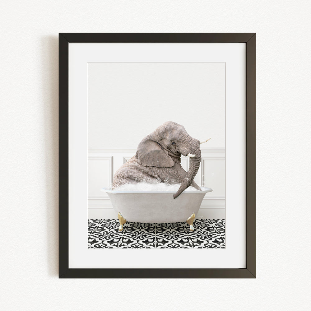 A gray elephant sitting in a white bathtub filled with water, surrounded by a black and white patterned rug.