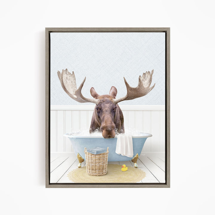 A moose with large antlers is sitting in a bathtub filled with water, surrounded by rubber ducks.